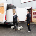 Mayfair Worktops Stonemasons unloading a White Macaubus Quartz worktop slab from a van using a trolley