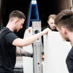 Mayfair Worktops Stonemasons handling a White Macaubus Quartz worktop slab during fitting preparation