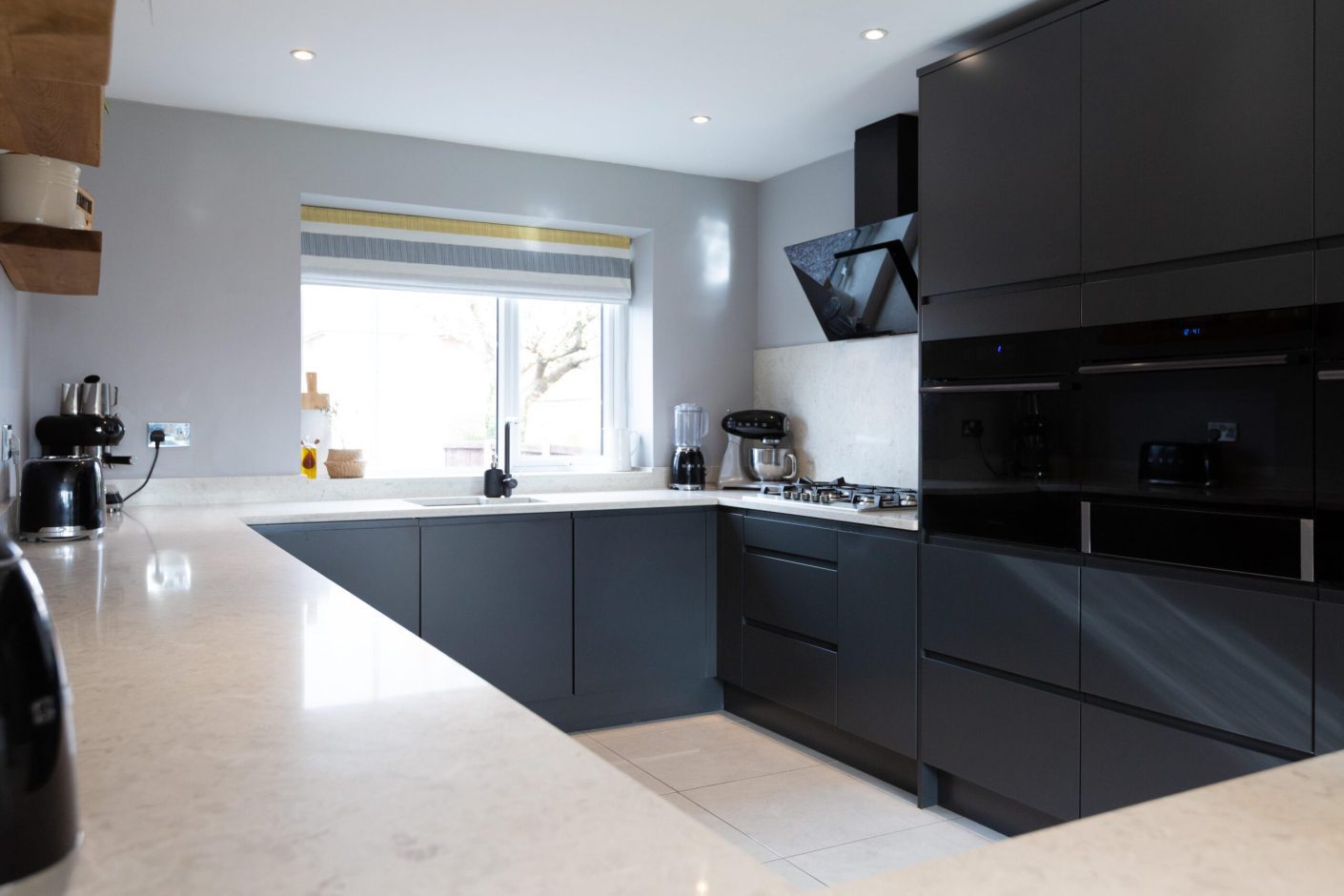 Modern kitchen with Grey Drift Quartz worktops fitted to an L-shaped run and window sink area