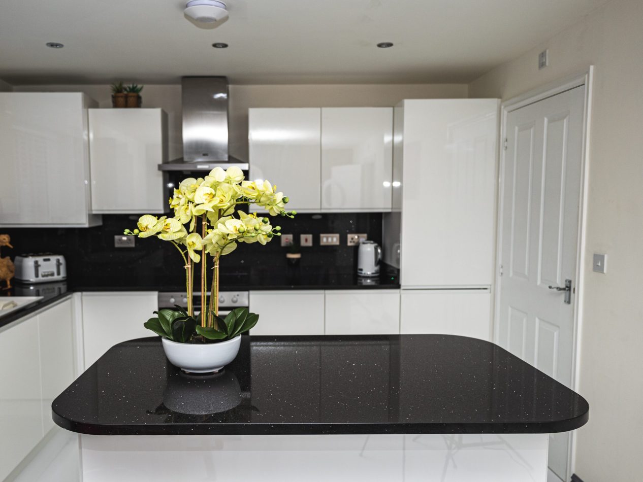 Modern kitchen with a Black Starlight Quartz island worktop showing a deep black surface with subtle sparkle
