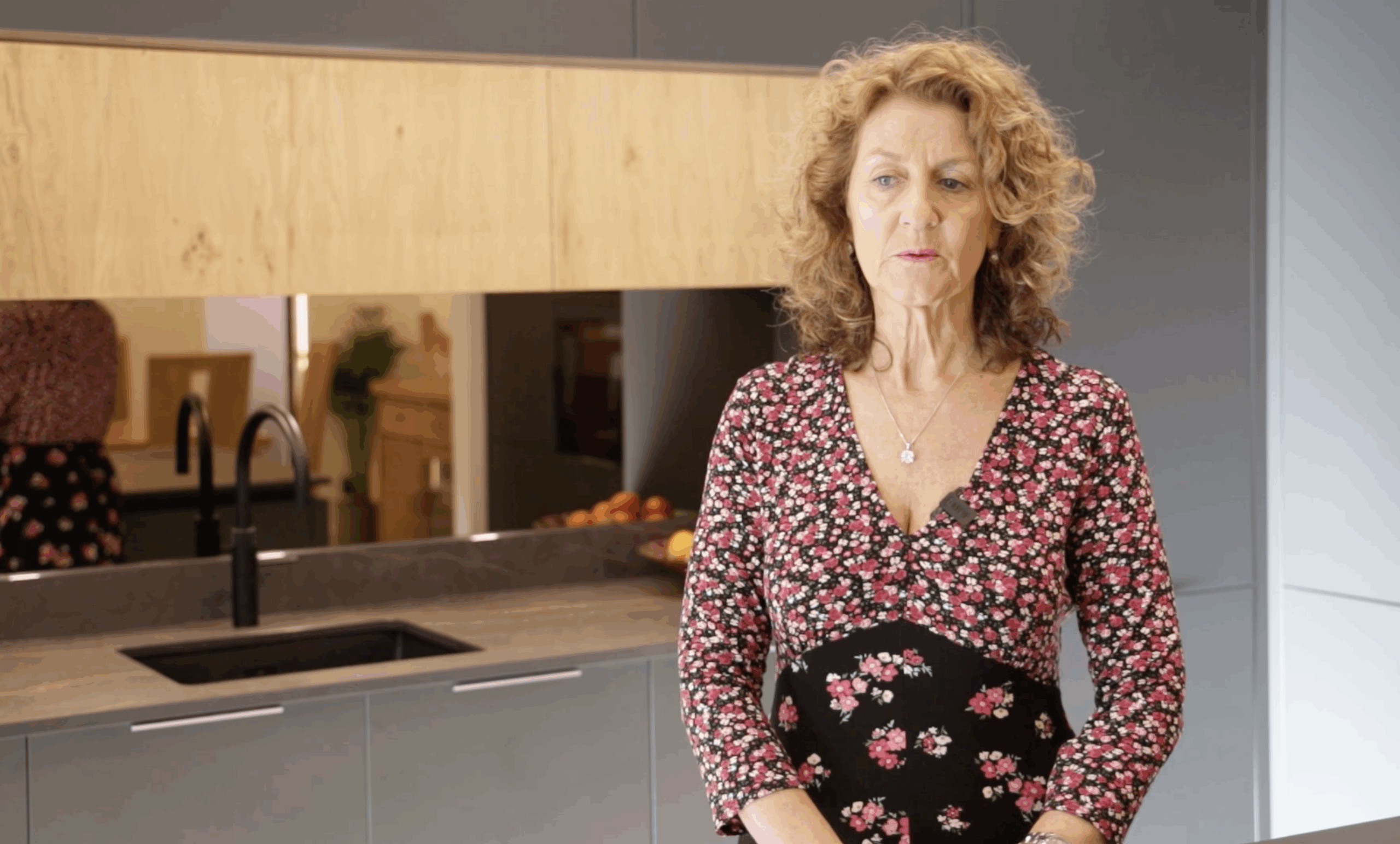 Customer testimonial portrait for a Laurent Porcelain worktop project, photographed in a modern showroom kitchen setting.