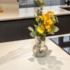 Volakas White Porcelain worktop surface with light grey veining, shown with a vase of flowers on top.