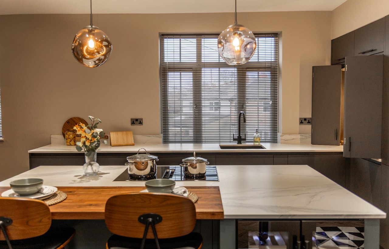 Volakas White Porcelain worktops in a modern kitchen with island seating and pendant lighting