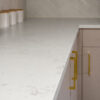 Carrara Quartz worktop with subtle grey veining in a modern kitchen featuring brass handles