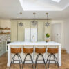 Full kitchen view featuring an Eternal Calacatta Quartz island with bar stools