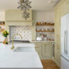 Eternal Calacatta Quartz worktops around sink area in a modern kitchen with gold tap and sage cabinets