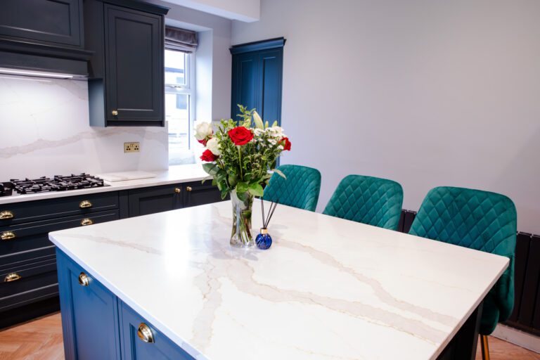 Britannicca Calacatta Quartz island worktop with seating showing flowing warm grey veining across the polished white surface