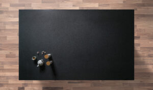 Overhead view of a honed Absolute Black Granite worktop showing a matte black surface, photographed from above with a small styled tray in the corner.