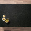 Overhead view of an Angola Black Granite worktop showing a dark speckled pattern, photographed from above with a small styled tray in the corner.