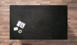 Overhead view of a Black Pearl Granite worktop showing the dark flecked pattern, photographed from above with a small styled tray in the corner.