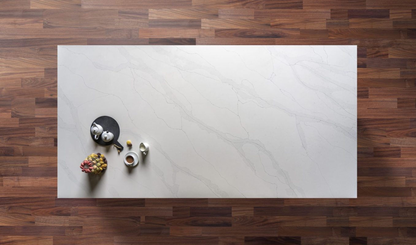 Quartz worktop shown from above with pale surface and subtle grey veining laid out on a wood floor setting
