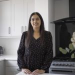 Nadiya customer testimonial image in her kitchen with Classic White Quartz worktops visible in the background