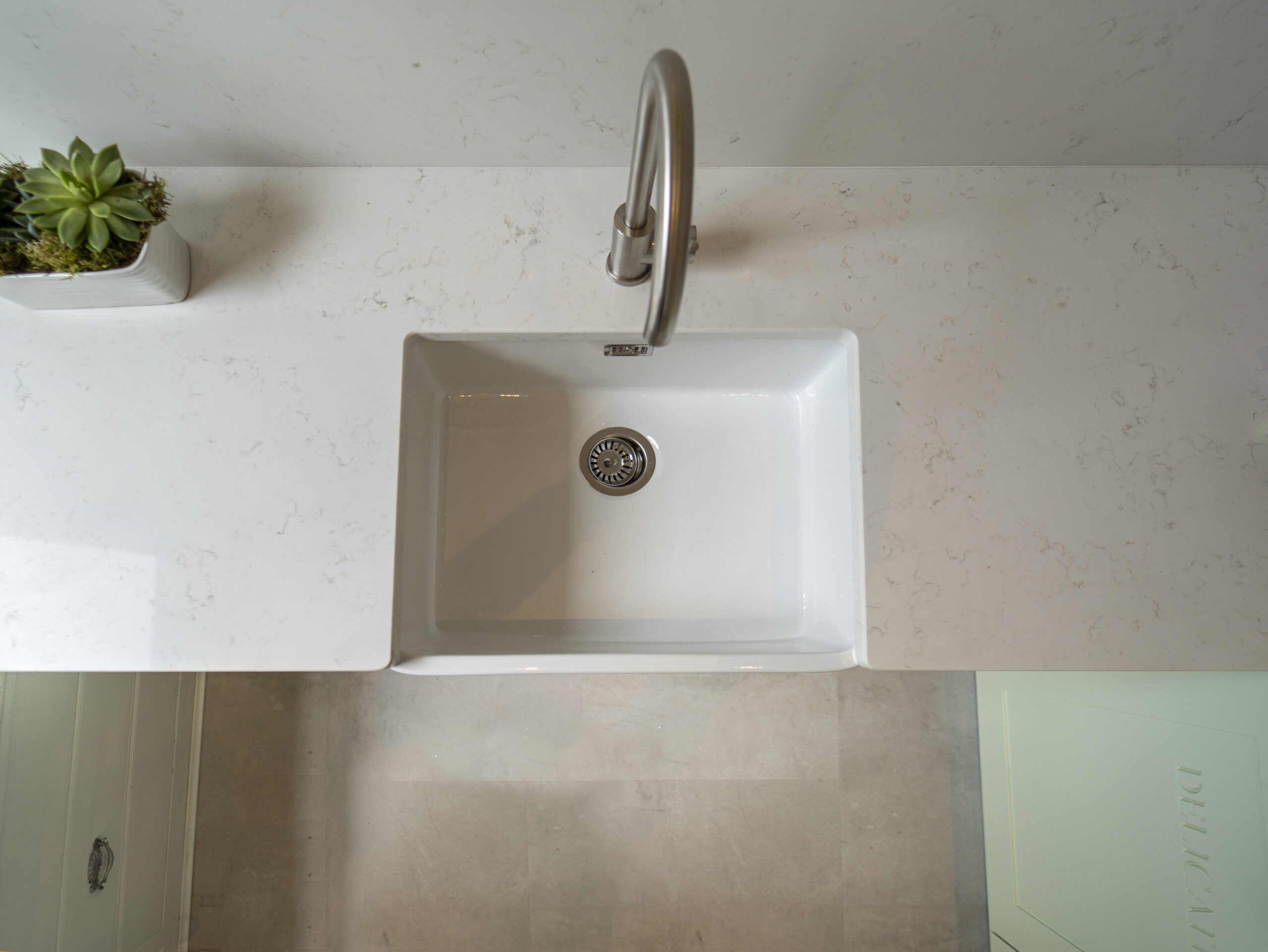 Carrara Quartz worktop around a white inset sink in a contemporary laundry room
