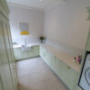 Carrara Quartz worktops in a clean, modern laundry room with mint green cabinets
