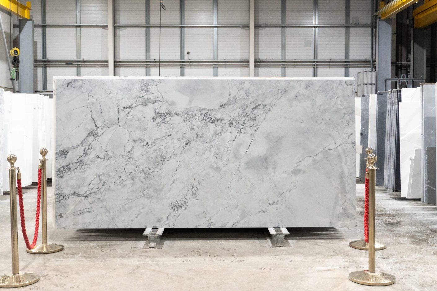 Calacatta Super White Porcelain full slab on a display stand, showing a bright white base with layered grey veining and soft shading
