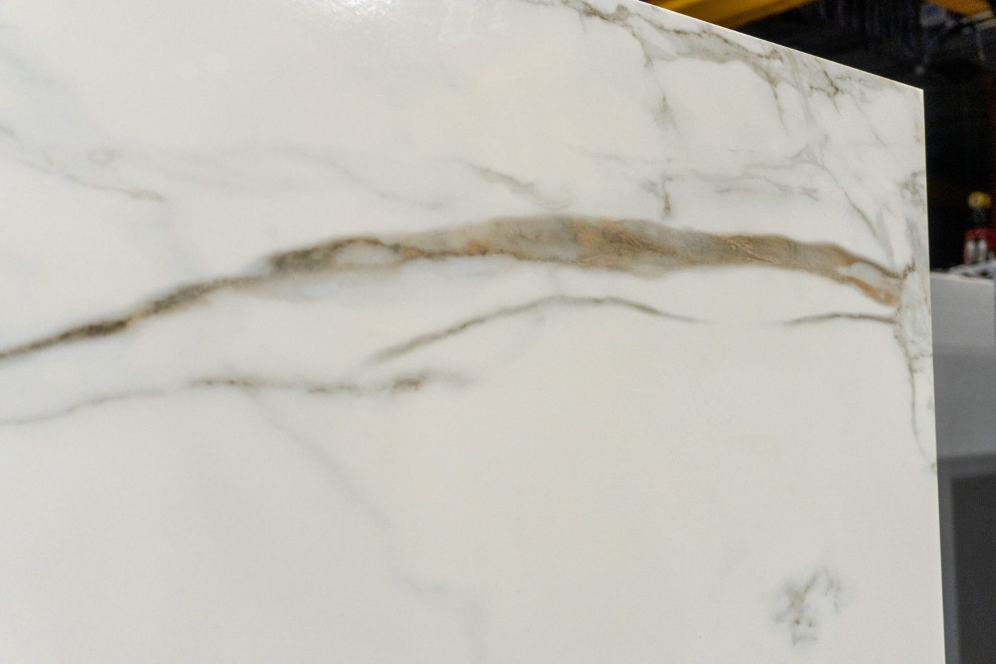 Calacatta Vagli Gold Porcelain close-up showing soft gold and grey veining across a white surface