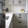 Classic White Quartz worktop run in a modern kitchen with grey cabinetry, showing a smooth white finish