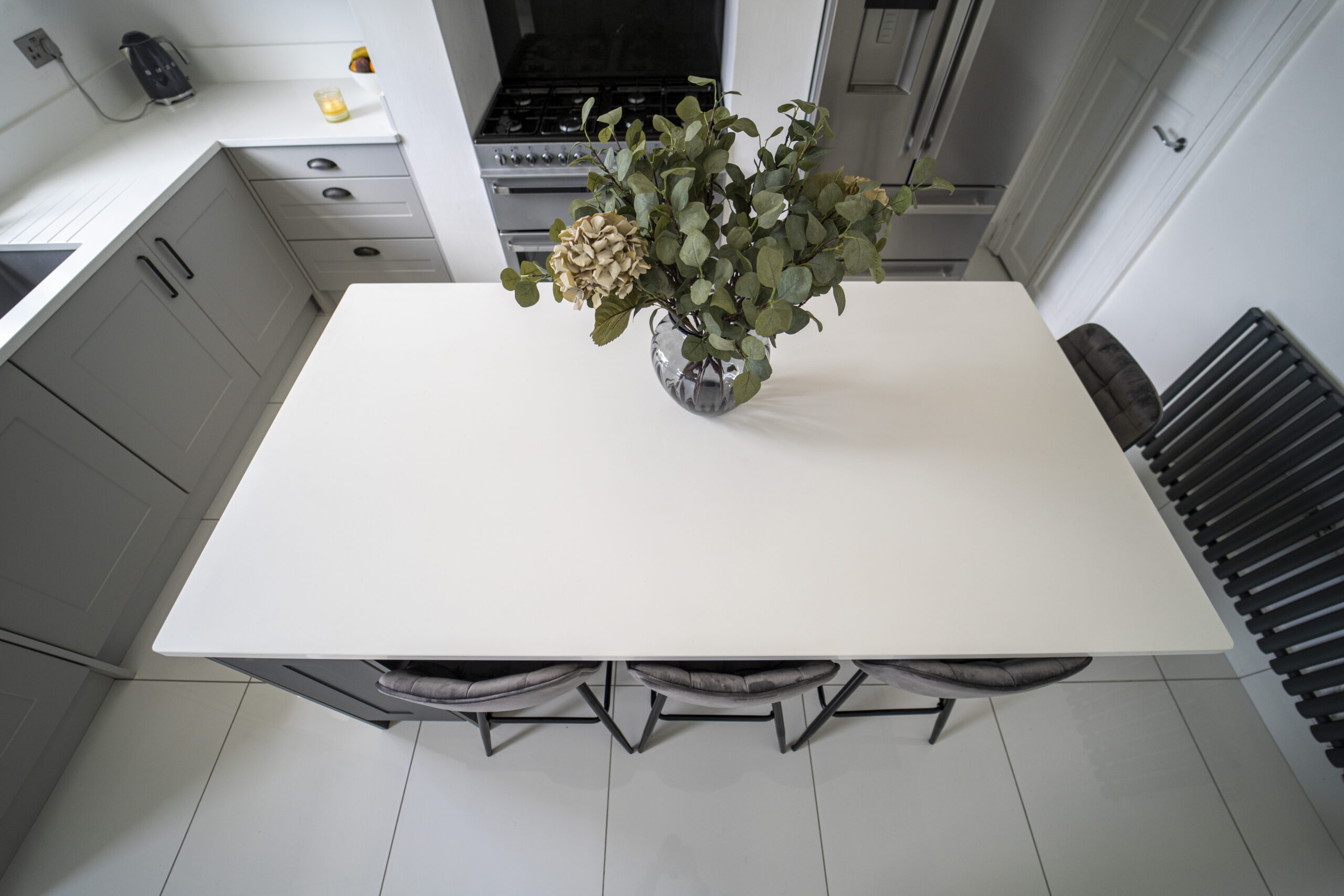 Overhead view of a Classic White Quartz kitchen island showing a smooth bright surface with seating below