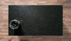 Overhead view of an Emerald Pearl Granite worktop showing a dark base with shimmering green flecks, photographed from above with a small styled tray in the corner.