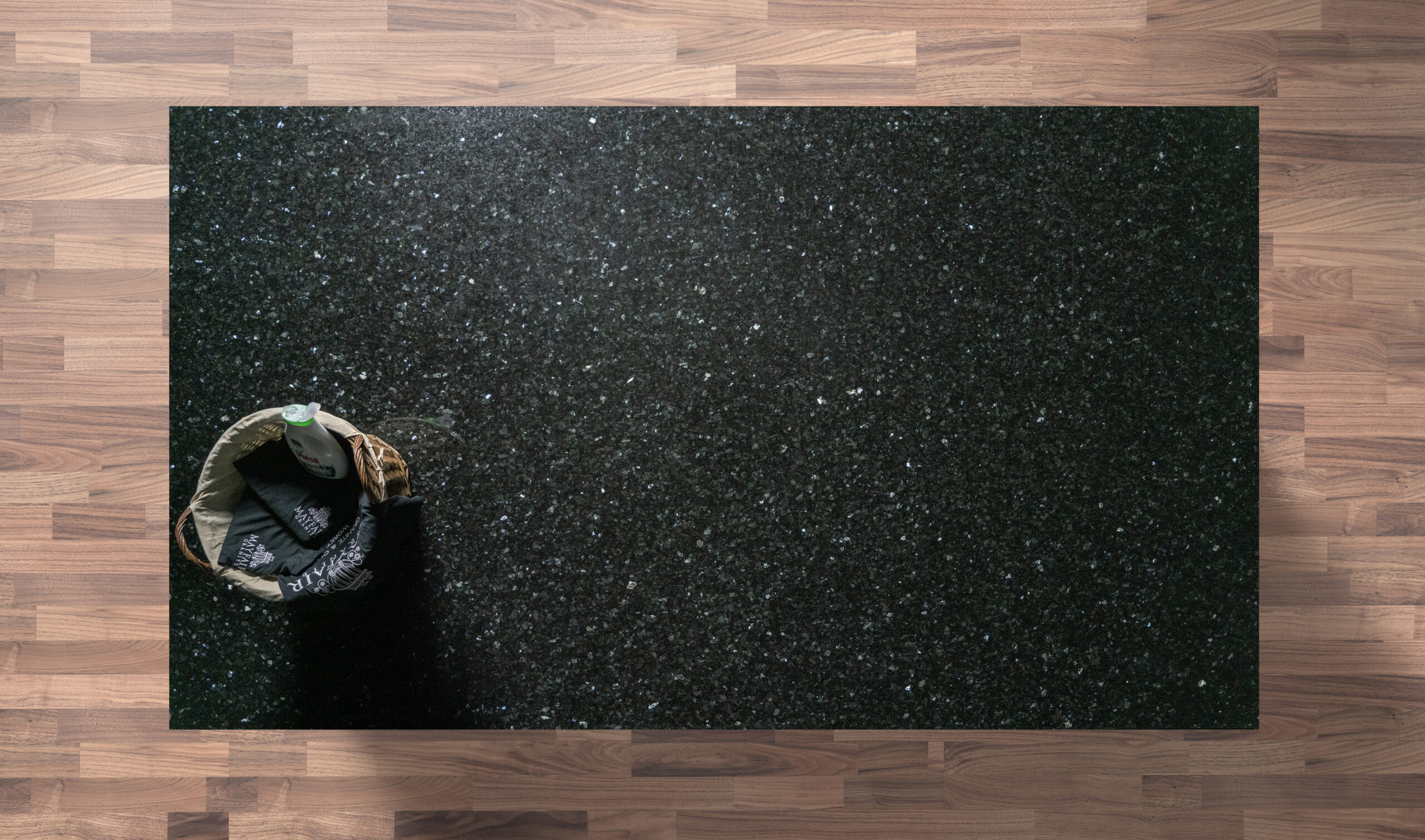 Overhead view of an Emerald Pearl Granite worktop showing a dark base with shimmering green flecks, photographed from above with a small styled tray in the corner.