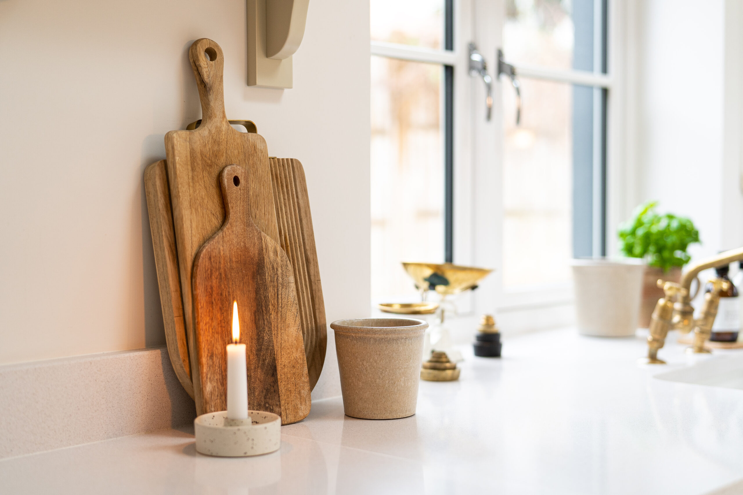 Ice White Quartz worktop by a kitchen window with chopping boards and accessories on the bright white surface