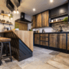 Wide angle kitchen view with Steel Grey leather Granite worktops and an island breakfast bar, showing rustic wood cabinetry, bar stools and stone effect flooring.