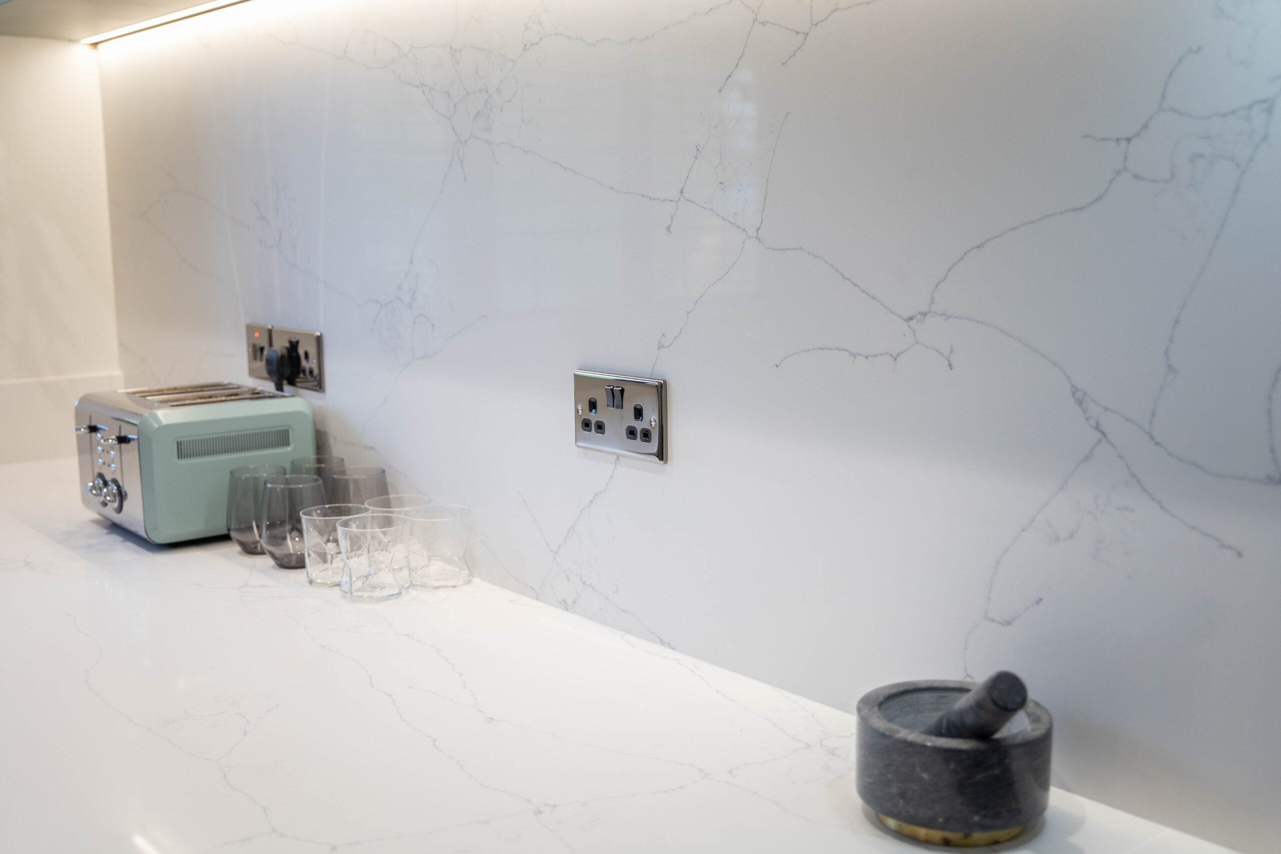 White Macaubus Quartz worktop close-up showing soft grey veining across a smooth white surface