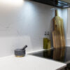 White Macaubus Quartz worktop and splashback corner with subtle veining beside kitchen accessories