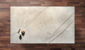 Overhead view of an Ivory Spice Granite worktop showing warm cream tones and soft natural veining, photographed from above with a small styled tray in the corner.