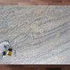 Overhead view of Ivory Wave Granite worktop showing flowing blue grey veining and natural movement, photographed from above with a small styled tray in the corner.