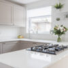 Bright kitchen view featuring Bluetta Carrara Quartz worktops with a hob set into the smooth white surface