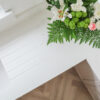 Bluetta Carrara Quartz worktop corner close-up showing a smooth edge and clean white finish near flowers