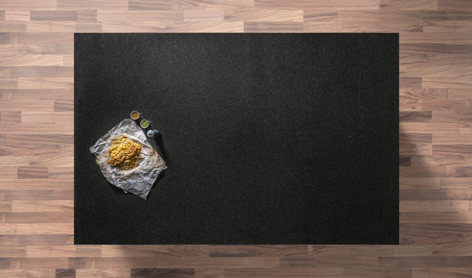 Overhead view of a Nero Impala Granite worktop showing a consistent dark grey speckled pattern, photographed from above with a small styled tray in the corner.