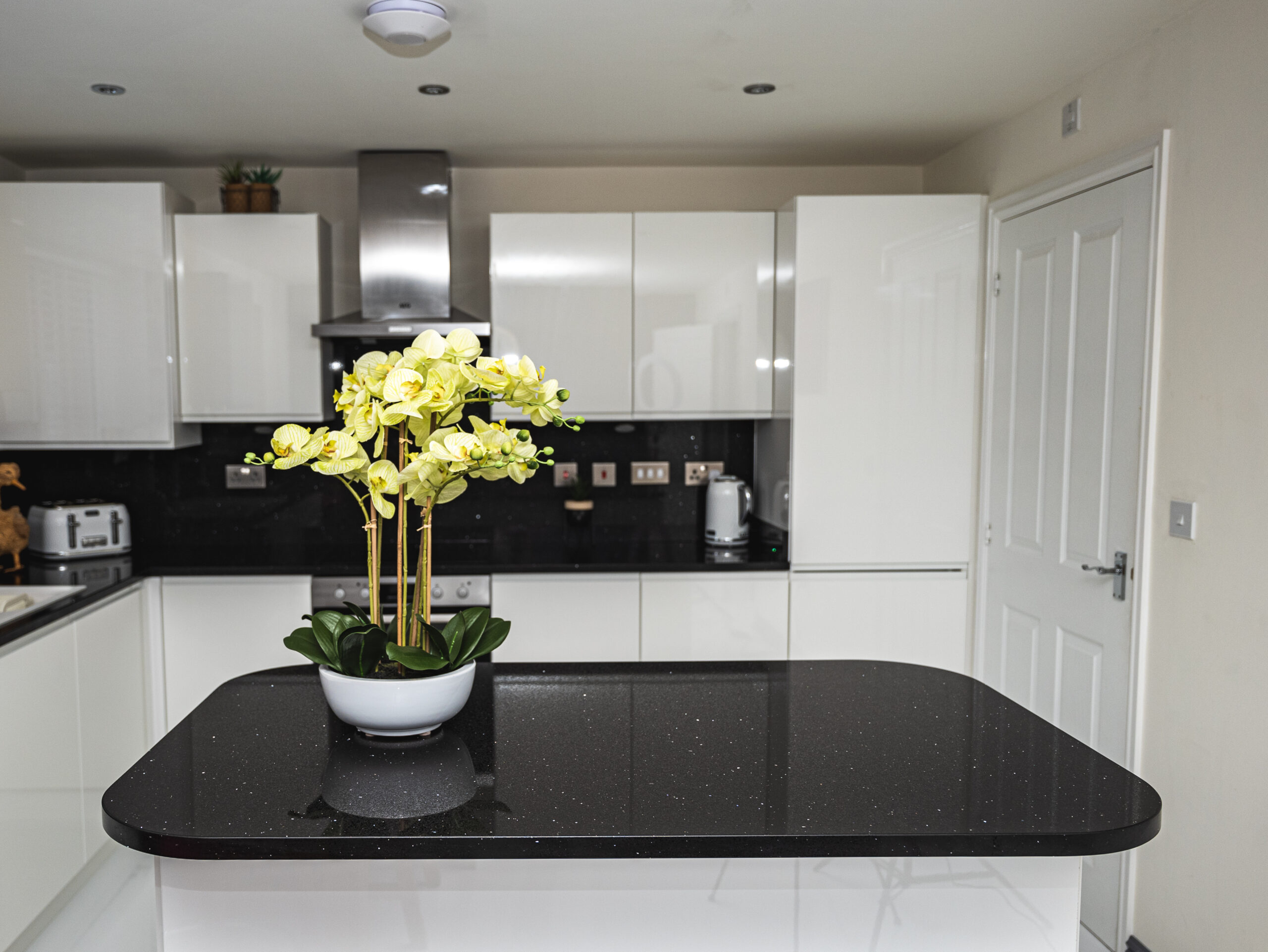 Modern kitchen with a Black Starlight Quartz island worktop showing a deep black surface with subtle sparkle