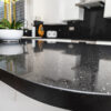Black Starlight Quartz worktop close-up showing reflective sparkle and a rounded island edge