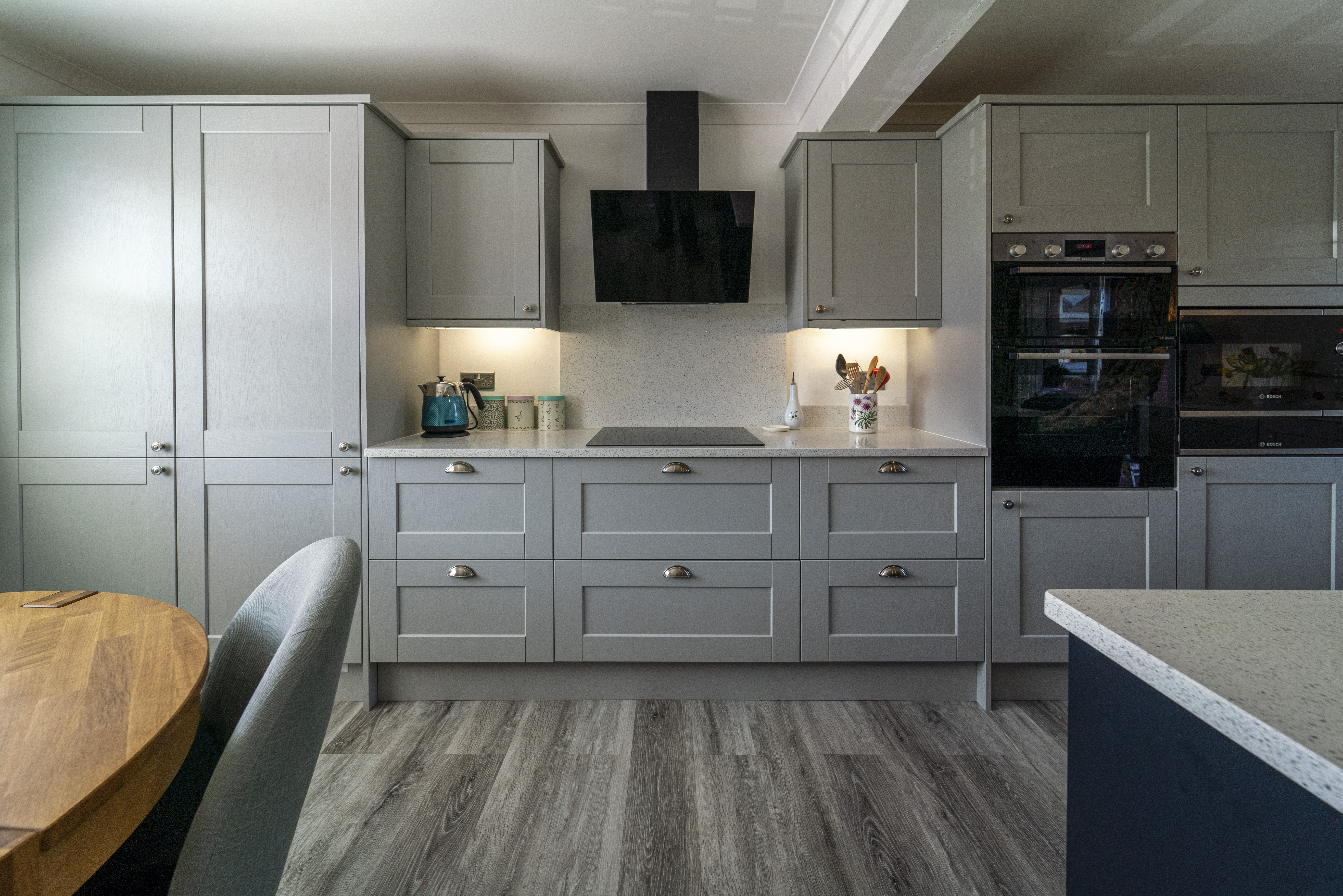 Modern kitchen fitted with White Starlight Quartz worktops and light grey cabinetry