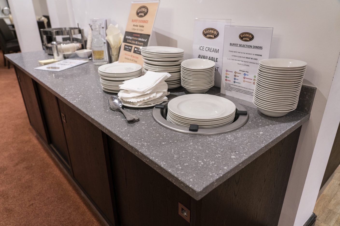 Titanium Quartz bar worktop with mid-grey speckled surface shown with plates and tableware on the counter