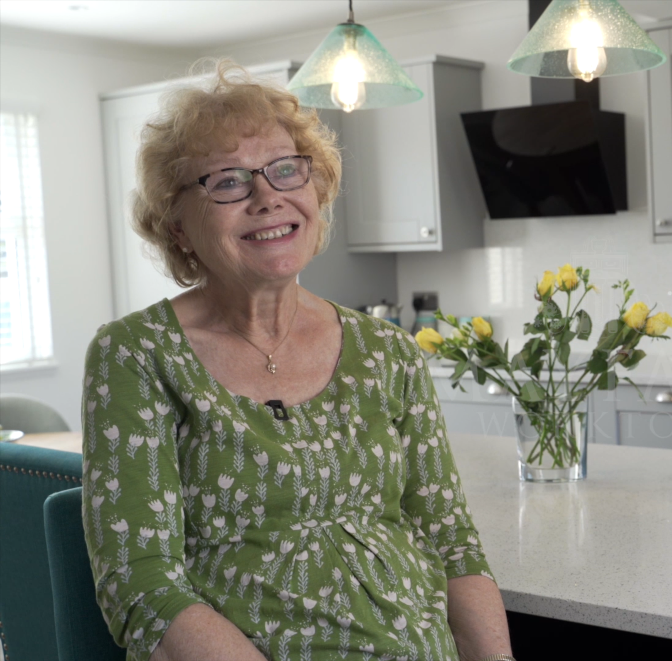 Customer giving a testimonial in her kitchen featuring White Starlight Quartz worktops from Mayfair Worktops