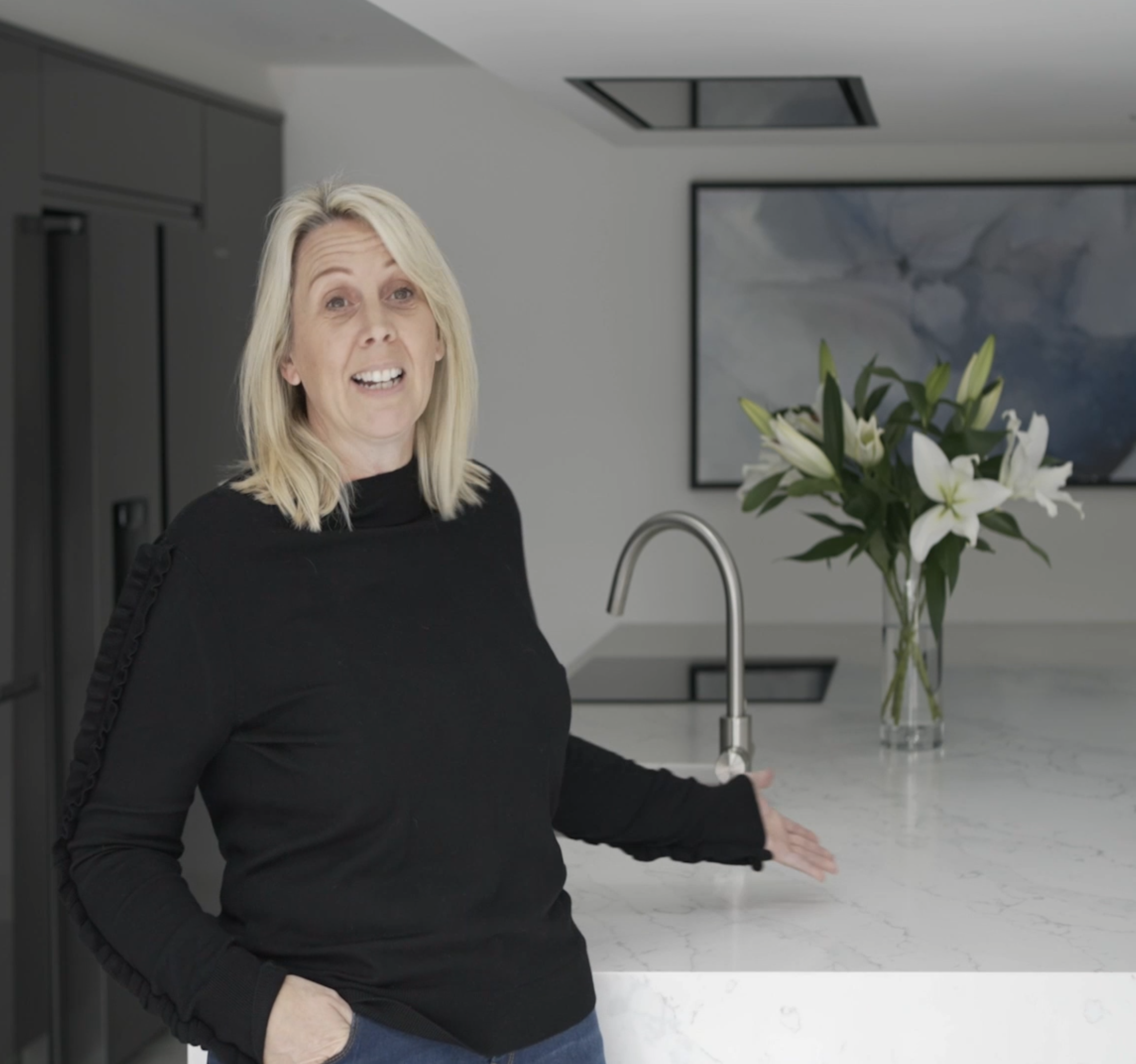 Janine giving a testimonial in her kitchen featuring White Calacatta Quartz worktops from Mayfair Worktops