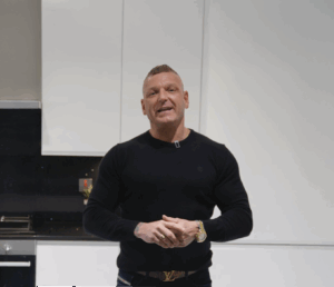 Dean customer testimonial image in a kitchen with Black Starlight Quartz worktop visible in the foreground