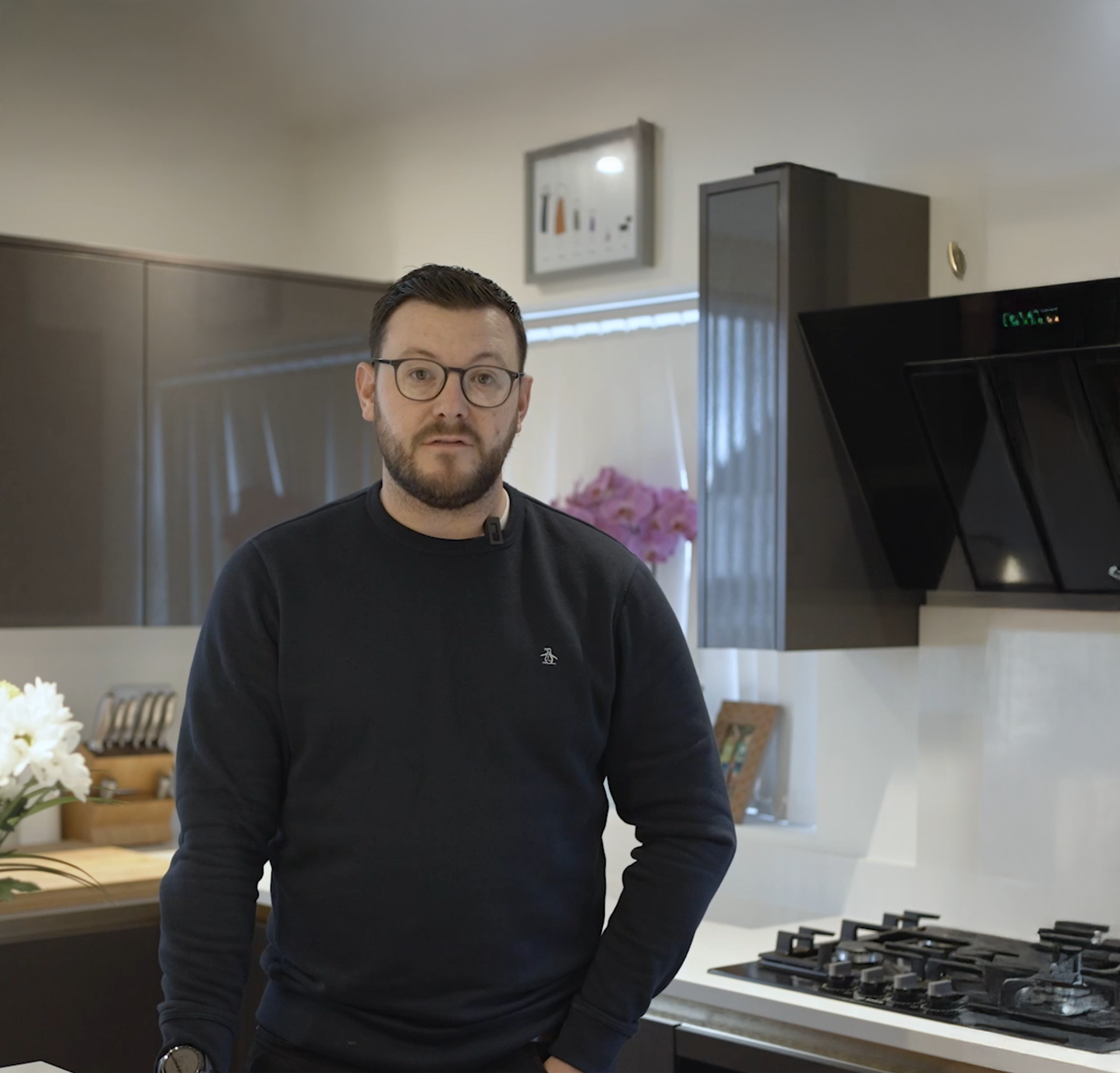 David standing in his kitchen beside an Imperial White Quartz worktop with a built-in gas hob