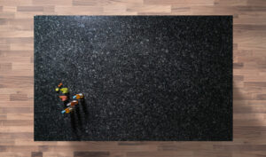 Overhead view of a Steel Grey Granite worktop showing a dark grey speckled pattern, photographed from above with a small styled tray in the corner.