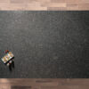Overhead view of a Steel Grey leather Granite worktop showing fine speckling and a textured finish, photographed from above with a small styled tray in the corner.