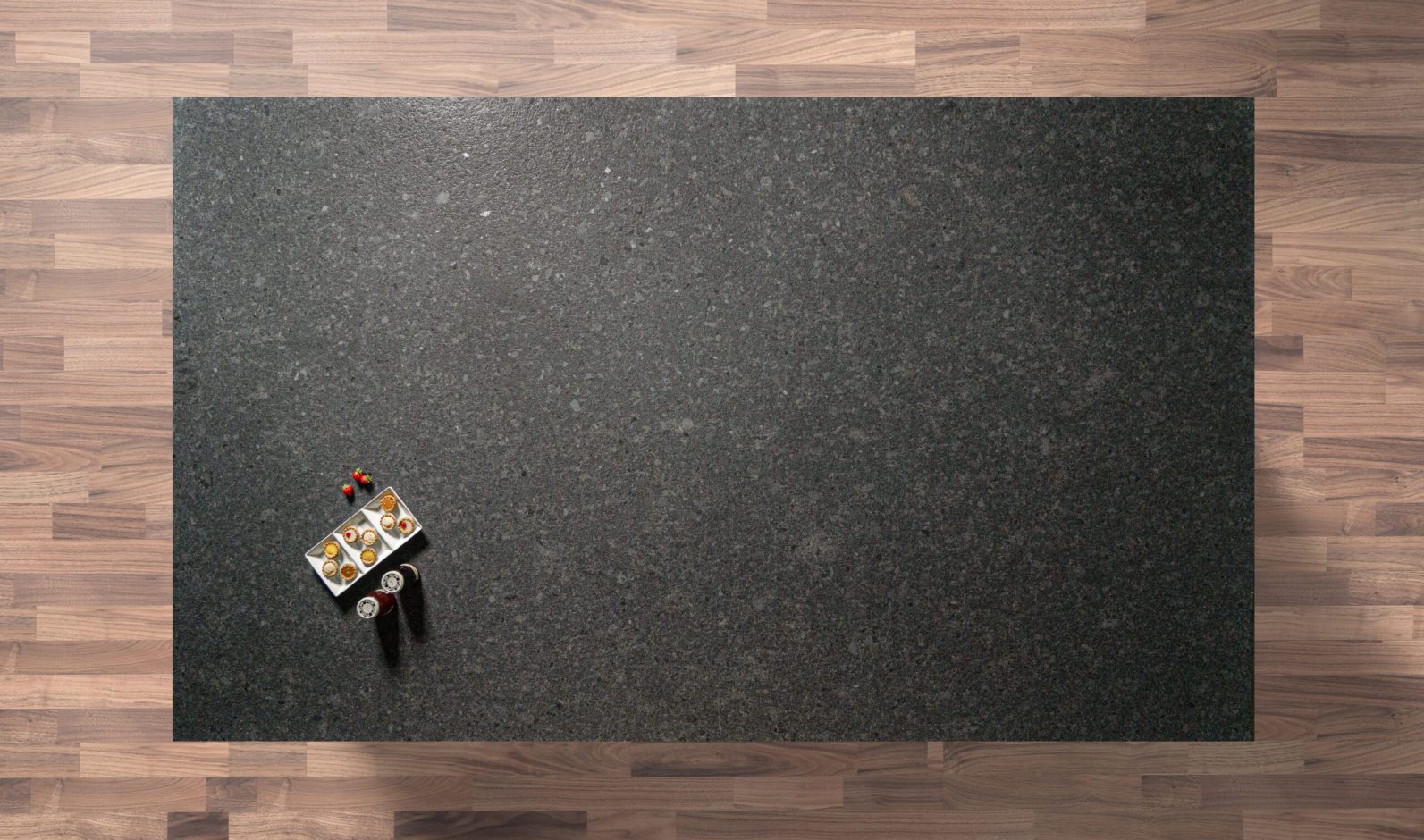 Overhead view of a Steel Grey leather Granite worktop showing fine speckling and a textured finish, photographed from above with a small styled tray in the corner.