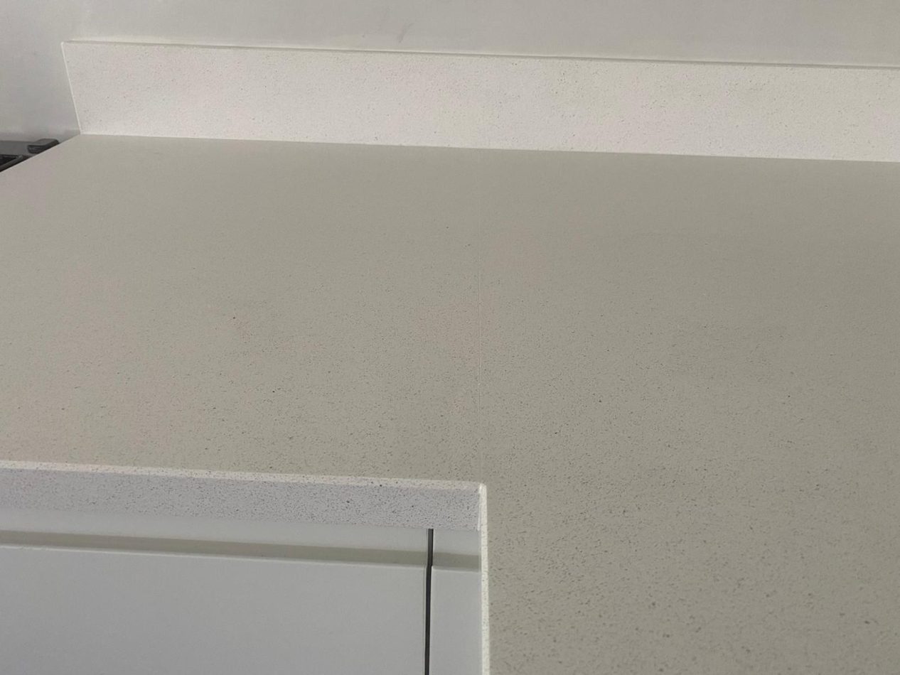Close-up of Stardust Quartz worktop showing light speckled white surface with smooth polished edge