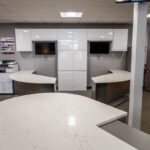 Benchmarx Witney showroom display featuring White Macaubus Quartz worktops with curved edges and a smooth white finish
