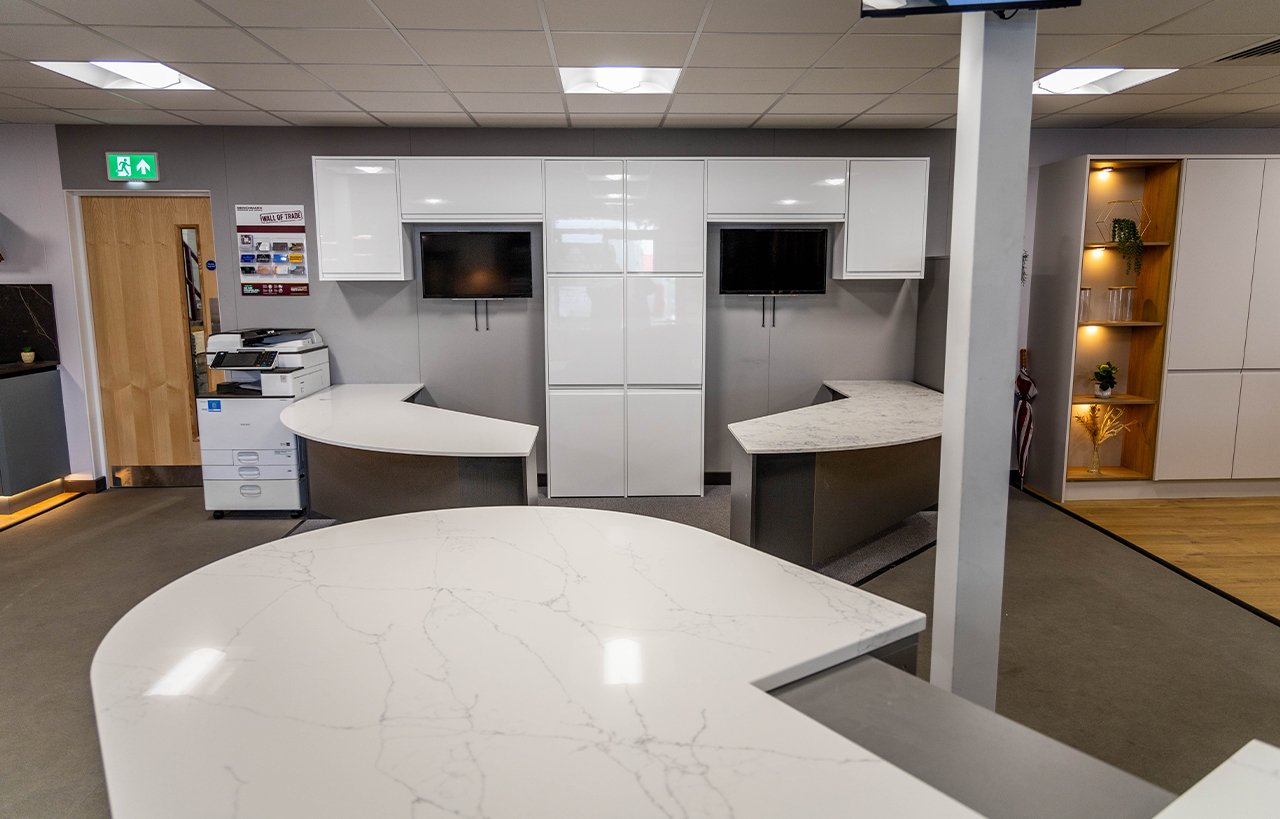 Benchmarx Witney showroom display featuring White Macaubus Quartz worktops with curved edges and a smooth white finish