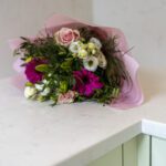 Flower bouquet placed on Carrara Quartz worktop in a pastel kitchen