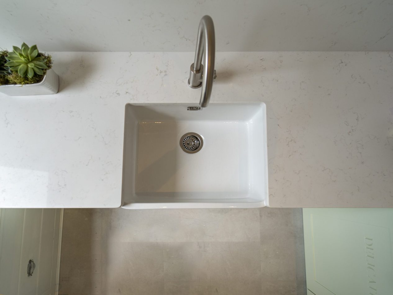 Carrara Quartz worktop with succulent arrangement beside the sink in a laundry room