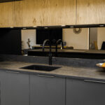 Laurent Porcelain worktop installed along a sink run beneath warm wood cabinetry, with a black tap and undermount sink.